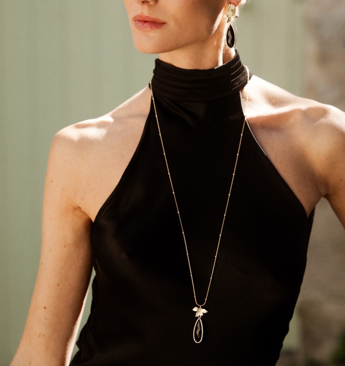 boucles d oreille dore a l or fin tout en longueur avec une attache doree a l or fin mate et une goutte en verre noire style ulta elegant et chic
